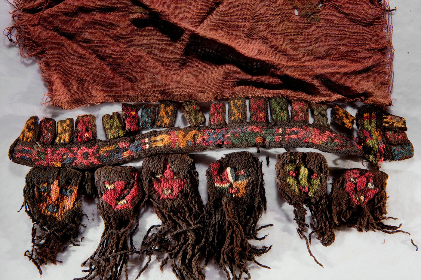 The sacred symbols of the Nasca reverberate through their material culture. Adorning the border of a ceremonial shawl from Cahuachi, long-haired heads mimic real sacrificial heads.